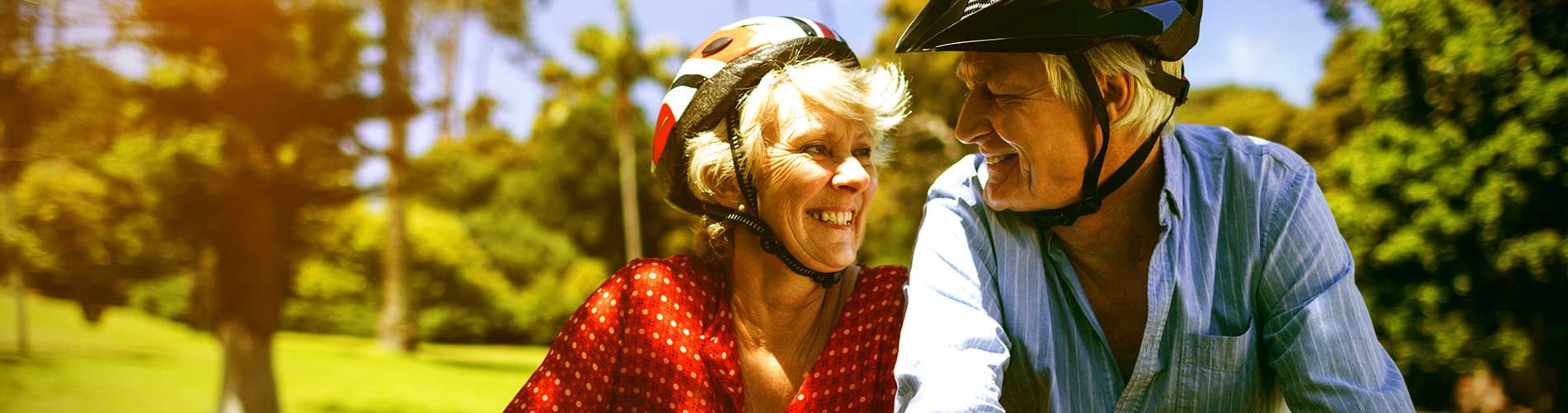 Senior couple smiling at each other on a bike ride